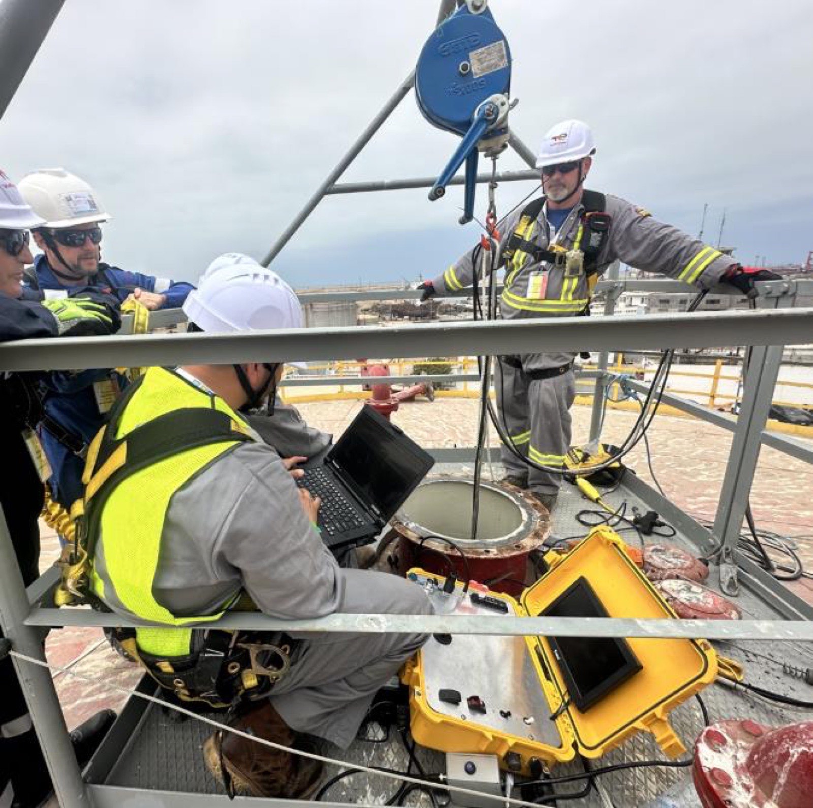 BSI field crew deploying an in-service robotic scanner through a tank roof manway